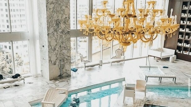 A luxurious indoor pool area with marble flooring, multiple seating areas, and a large chandelier. - Perfect Studio 5 Icon Brickell Pool spa gym View (Miami)