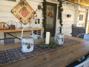 A wooden table with a candle, two rustic lanterns, and a decorative mat.