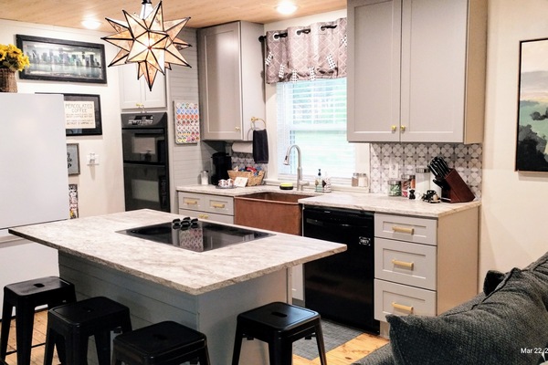 Bright, well-stocked full custom kitchen w/ stone counters & copper farm sink