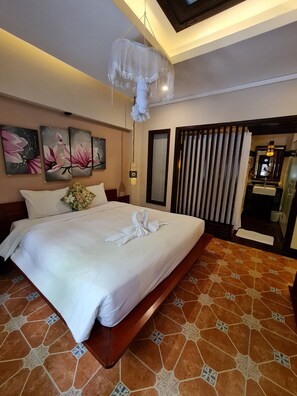 Deluxe Room, Pool View | Free minibar, in-room safe, desk, laptop workspace