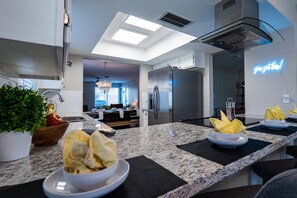 A modern kitchen with granite countertops, stainless steel appliances, and a neon sign. - Shuffleboard! Heated Pool! Live w/ 2 Kings Cool! (Chandler)