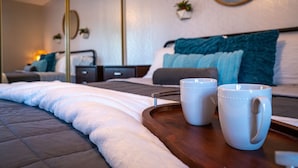 A neatly made bed with a white comforter and a wooden tray holding two white mugs. - 4BR w pool, shuffleboard, 2 king rooms (Chandler)