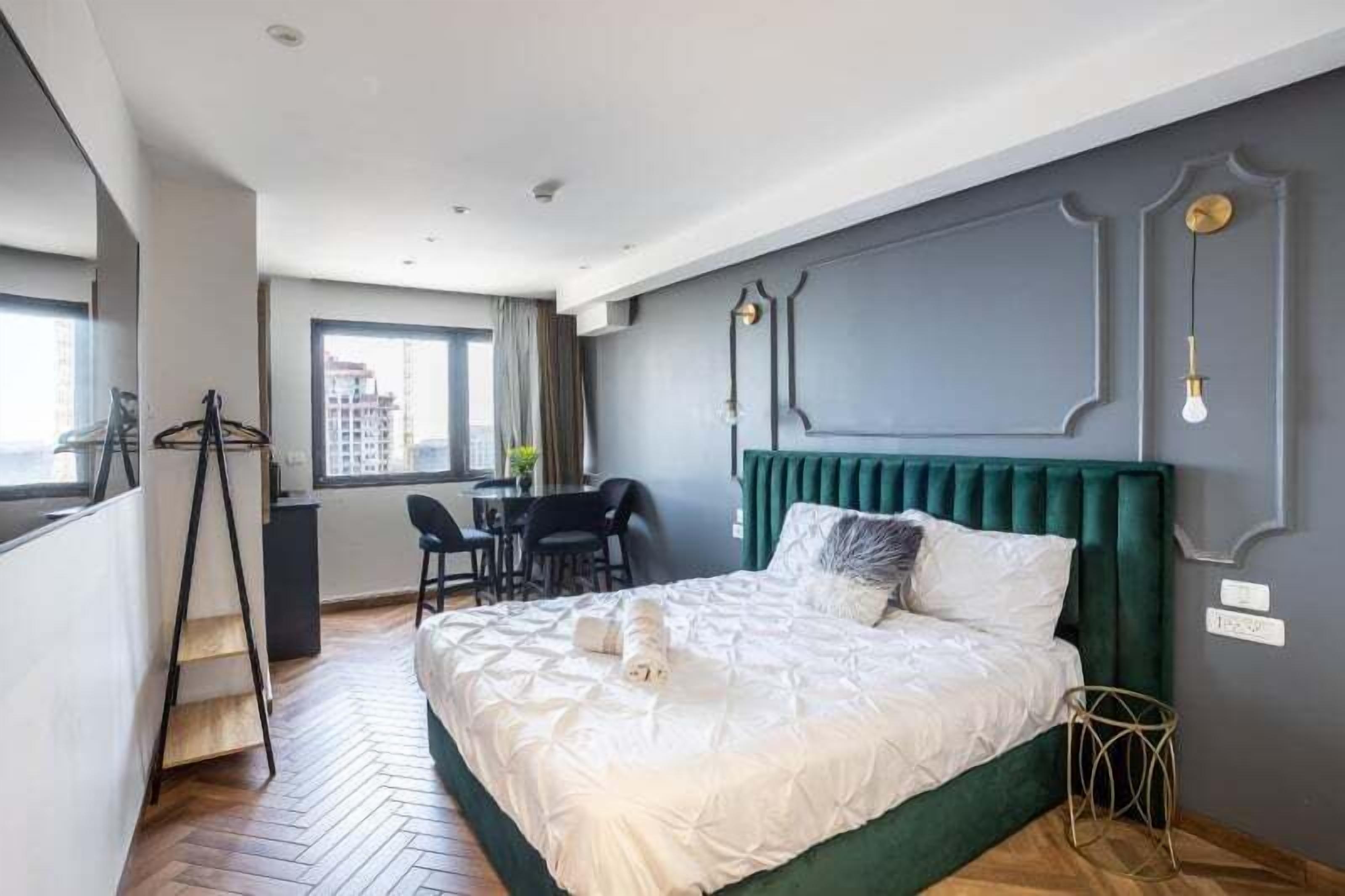 Une chambre à coucher moderne avec un grand lit, un bureau et une chaise.