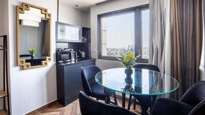 A modern kitchen with dark cabinets, a microwave, and a small window. - Nissim (Jerusalem)