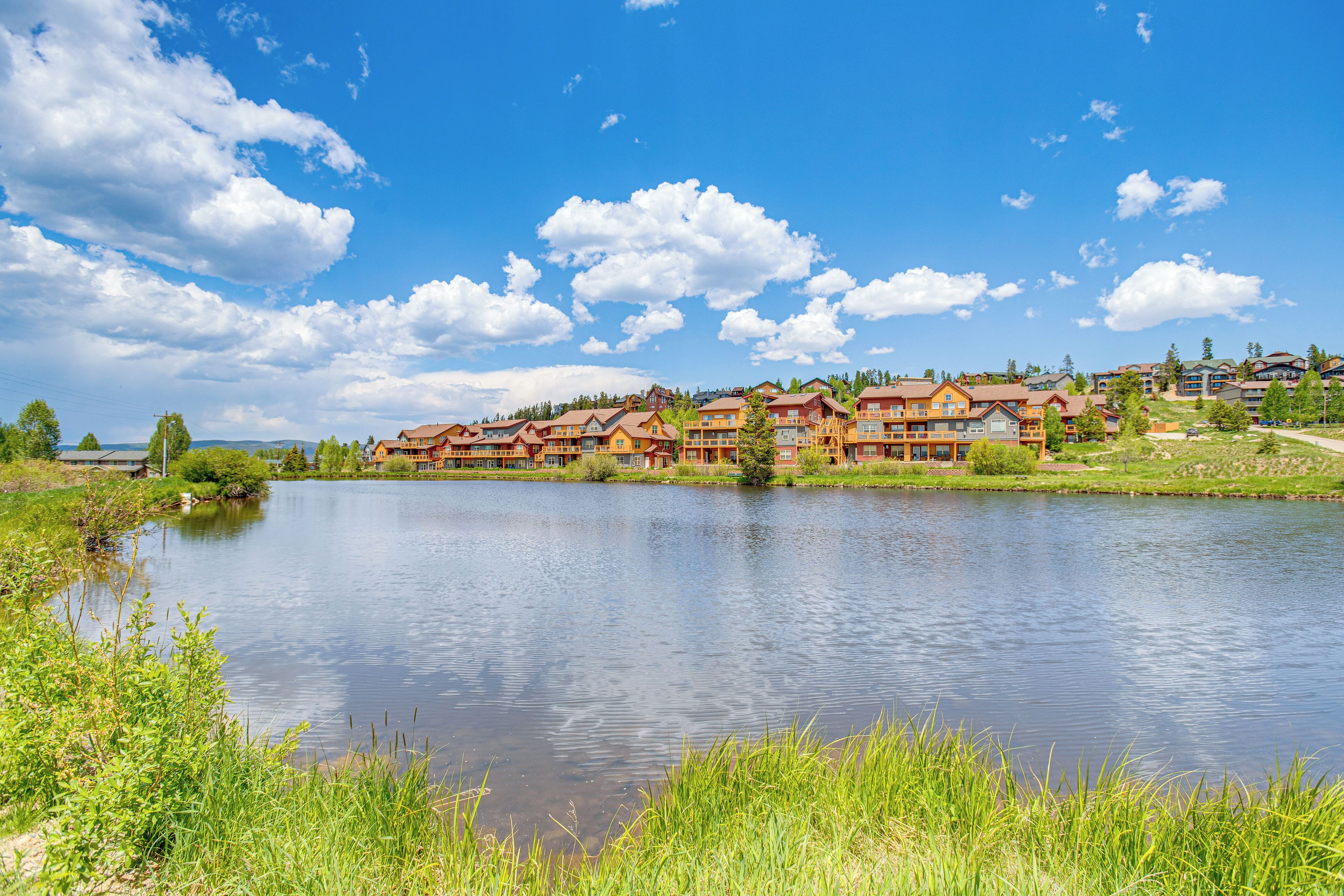 Ein Seehotel mit mehreren Holzbauten, blauem Himmel und ruhiger Seefläche.