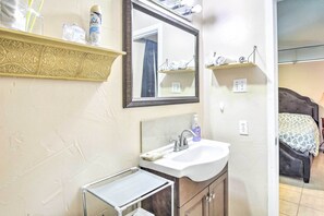 Une salle de bain avec un lavabo blanc, un miroir et un porte-serviettes.