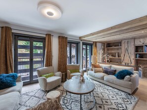 Un salón amplio con un gran ventanal, una mesa de centro redonda y un sofá.