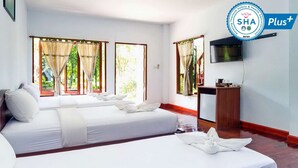 A hotel room with two beds, a TV, and a desk.