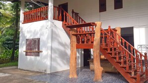 A two-story building with a wooden staircase and a balcony.