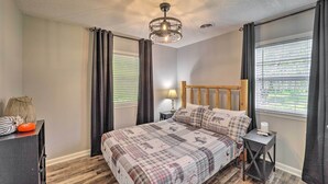 A bedroom with a bed, a nightstand, a lamp, and a window with curtains. - Deep Gap Cottage w/ Fire Pits - Hike & Ski! (Deep Gap)
