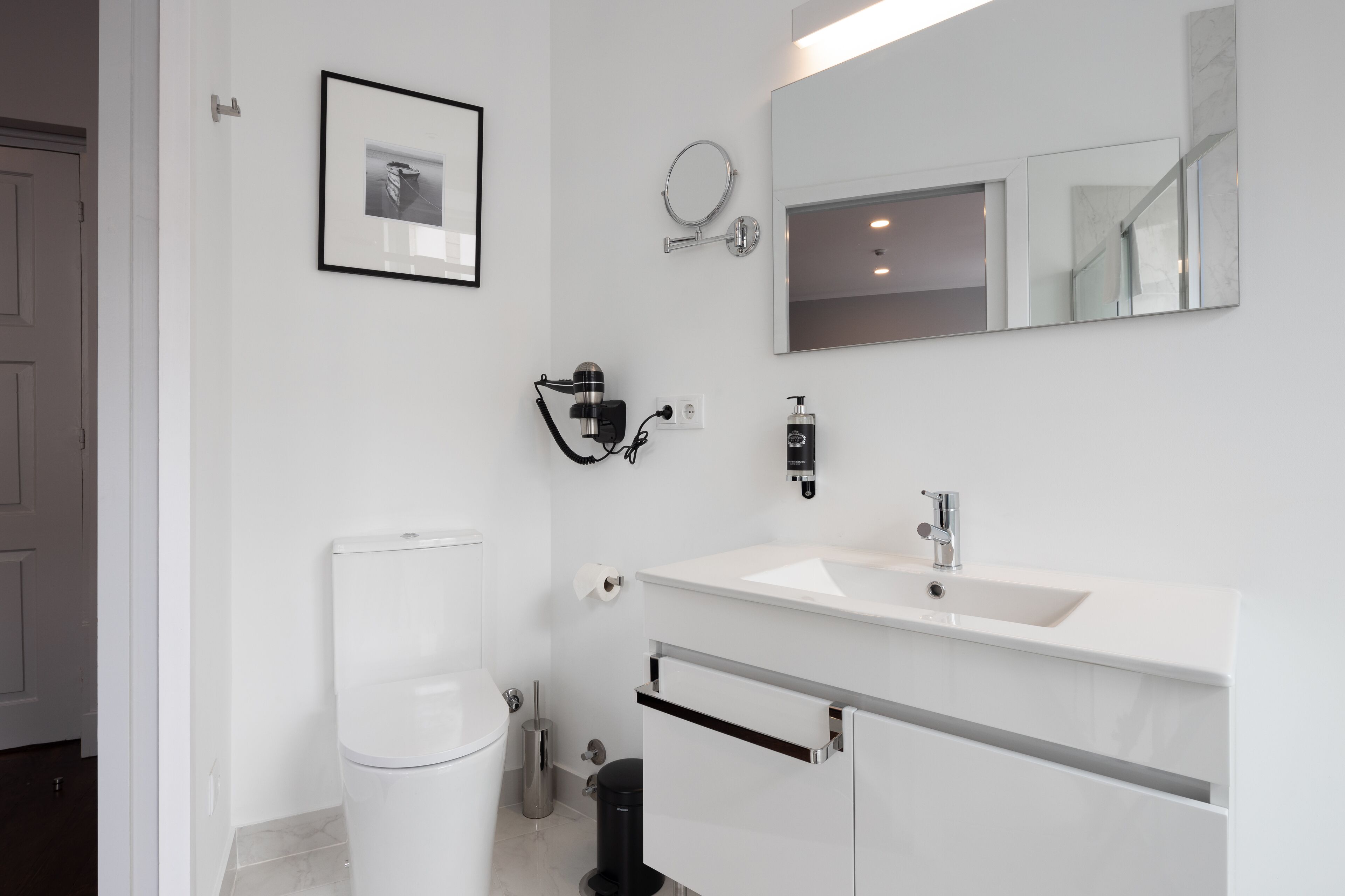 A modern bathroom with a toilet, sink, and mirror.