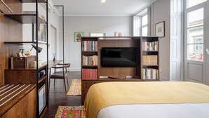 A modern bedroom with a bed, a TV, a bookshelf, and a desk. - Utopian - Design Suites Porto (Porto)