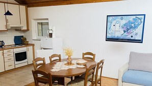 Un coin repas avec une table et des chaises en bois, un canapé blanc et un tableau au mur.
