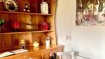 Une étagère en bois sur laquelle se trouvent divers objets, notamment une théière, une tasse rouge et un récipient blanc avec une étiquette.