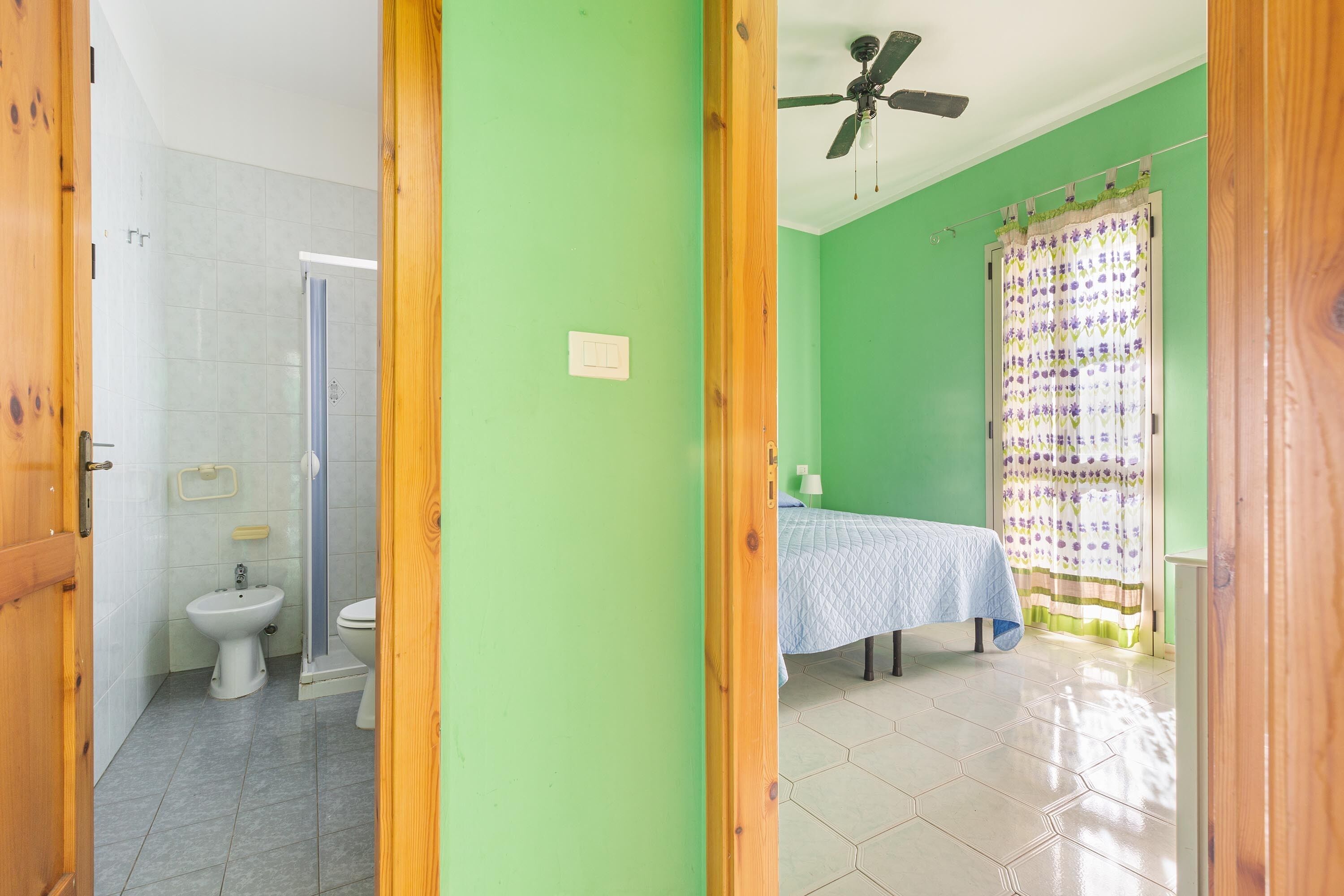 A bathroom with a toilet, bidet, and shower.