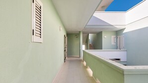 A corridor with a tiled floor, a staircase, and a balcony with a railing. - 2716 Baia Verde Apartments - Appartamento Timone (Gallipoli)