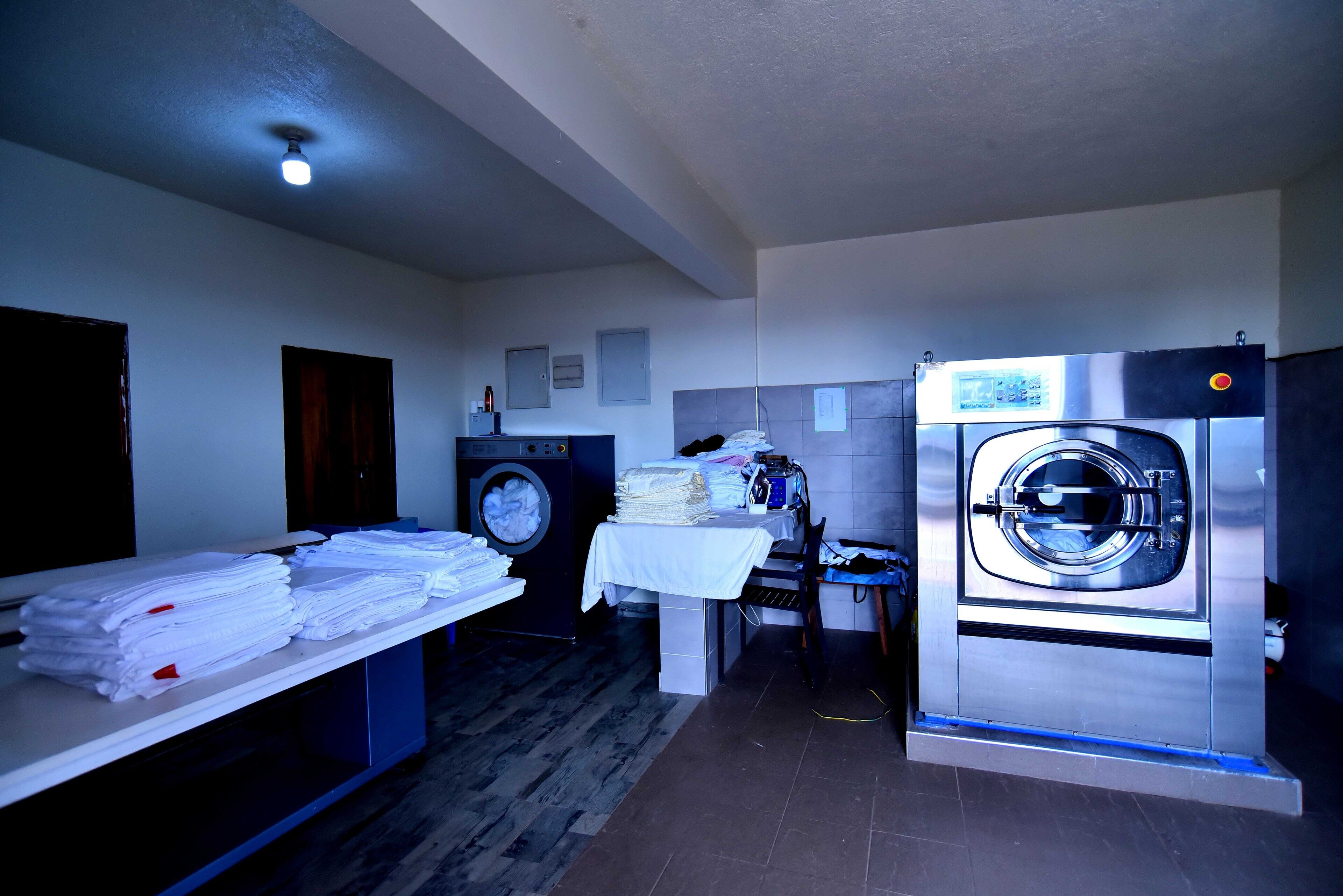 A laundry room with two washing machines, a table with folded towels, and a ceiling light.