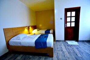 Un dormitorio con una cama de madera, una mesita de noche y una puerta.