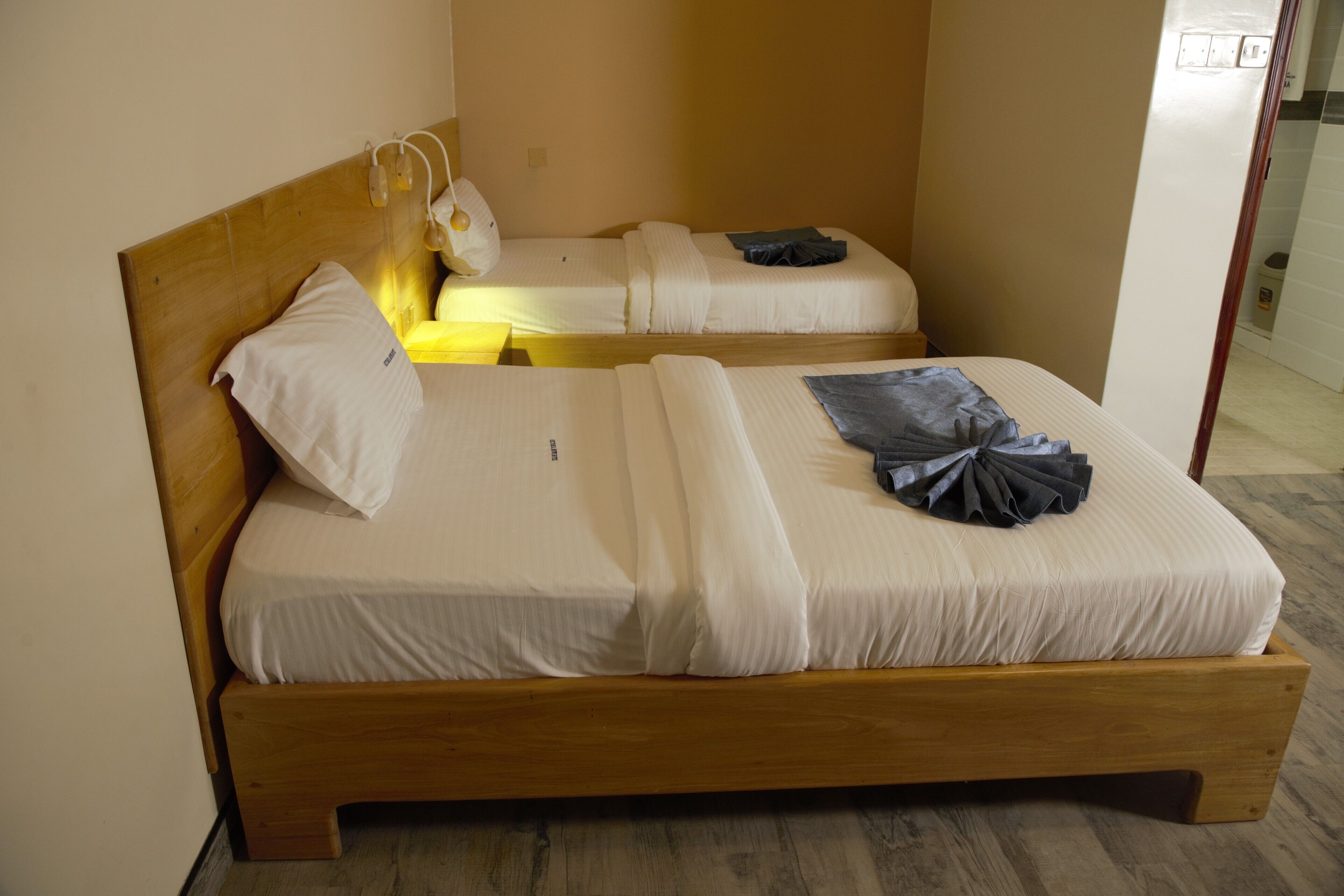 A double bed with a wooden headboard, two pillows, and a blanket.