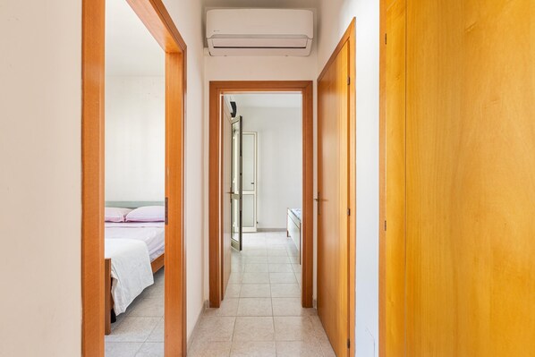 Un pasillo con puertas de madera y una unidad de aire acondicionado blanca en la parte superior.