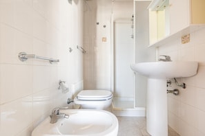 Ein Badezimmer mit Toilette, Bidet, Waschbecken und Dusche.