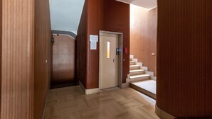 A hallway with wooden walls, a door, and a staircase leading to an upper floor. - 3012 Carra Apartment by Barbarhouse (Gallipoli)