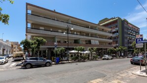 A multi-story building with balconies, a parking sign, and outdoor seating. - 3012 Carra Apartment by Barbarhouse (Gallipoli)