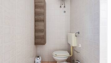 A bathroom with a toilet, sink, and cabinet.
