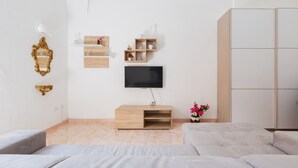 A modern living room with a flat-screen TV, a wooden cabinet, and a sofa. - 2380 Casa Crispi (Alezio)