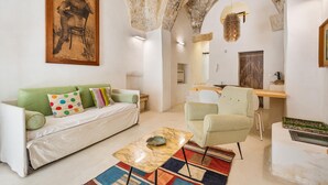 A living room with a green sofa, a white armchair, a marble coffee table, and a colorful rug. - 3011 Casa del Capitano by Barbarhouse (Racale)