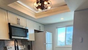 A modern kitchen with granite countertops, stainless steel appliances, and a large window providing natural light. - Beautifully renovated lakefront condo! Executive Rental, Monthly Rental (Lake Suzy)