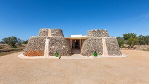 A stone structure with a central doorway and two green decorative elements.