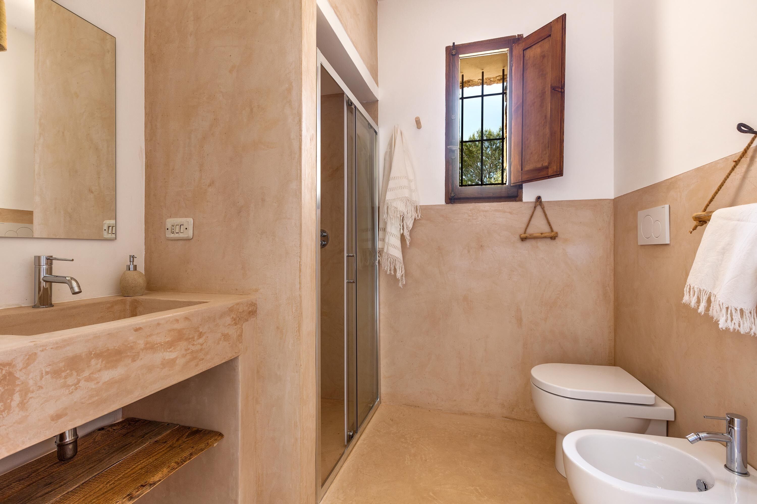 Une salle de bain avec un lavabo beige, des toilettes blanches et un espace douche.