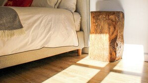 Une chambre à coucher avec un lit, une table de chevet en bois et deux appliques murales.