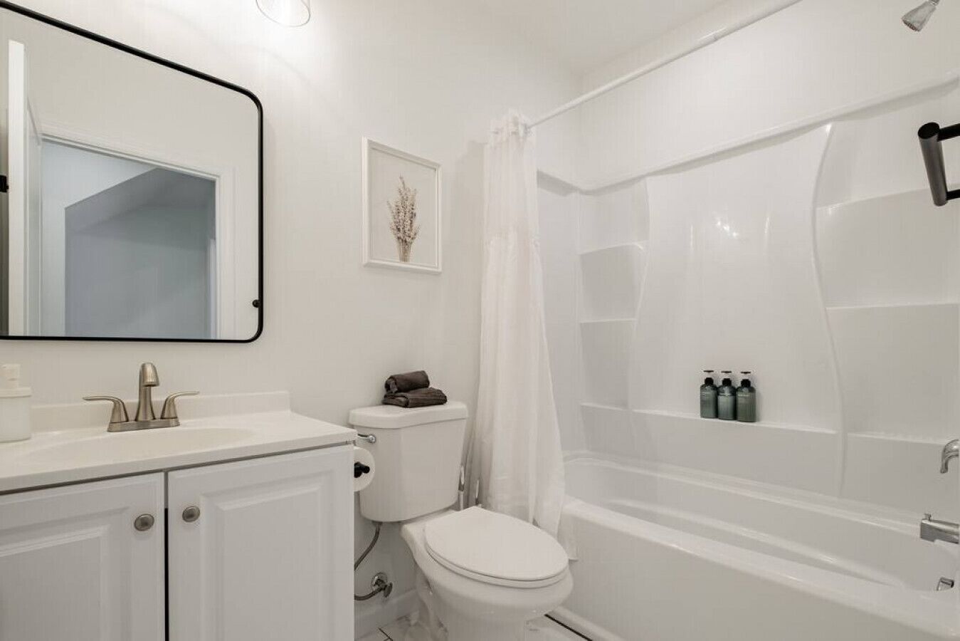 A bathroom with a toilet, sink, and shower area.