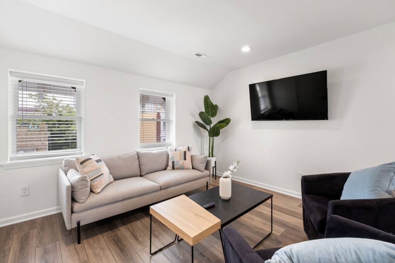Un salon moderne avec un canapé, une table basse et un téléviseur fixé au mur.