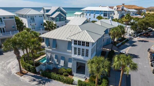 A coastal residential area with houses featuring gabled roofs and a swimming pool. - Splash Pool, Carriage House, Free Beach Chair Setup & Attraction Tickets! (Panama City Beach)