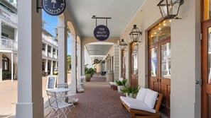 A covered outdoor corridor with a sign reading "The Salty Bottle," benches, and tables. - Splash Pool, Carriage House, Free Beach Chair Setup & Attraction Tickets! (Panama City Beach)