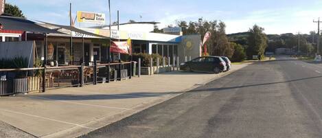 A street view with a restaurant named 'FISH CHIPS' and a 'Real Estate' sign.