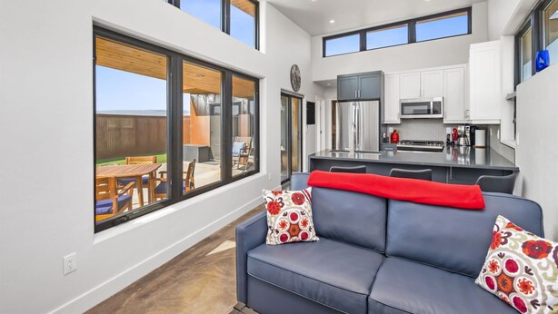 A modern kitchen with white cabinets, a microwave, and a refrigerator. - Joy of Life @ Palisade Legends (Clifton)