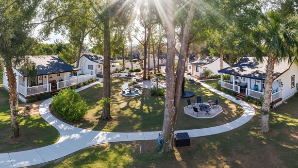 A residential area with multiple houses, a central circular driveway, and a small water feature. - Alling House (Orange City)