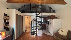 A spacious kitchen with wooden flooring, a white refrigerator, and a dining area with a table and chairs. - Alling House (Orange City)