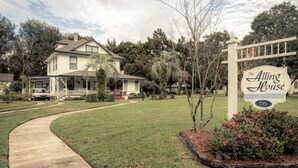 A two-story house with a front porch, a driveway, and a sign indicating 'The Alling House' with the number 215.