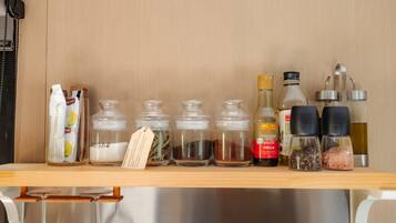 A shelf with various food items including jars of sugar, spices, and condiments.
