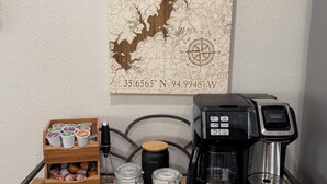 Una estación de café con un mapa, cafetera, jarrón de leche y tazas.
