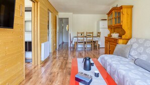 Ett rum med träpanel på väggarna, en soffa, ett bord med en vattenkokare och ett skåp.