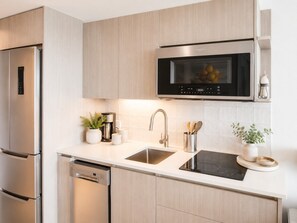 A modern kitchen with stainless steel appliances, a built-in microwave, and a sleek countertop design.