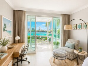A modern hotel room with a balcony, a desk, a chair, and a patterned ottoman.