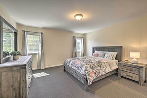 A bedroom with a bed, dresser, nightstand, and a window with curtains. - Glen Cove Home: Walk to Boardwalk + Dining! (Glen Cove)