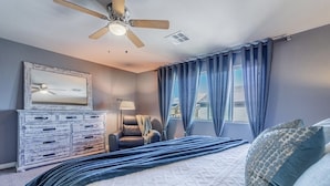 A bedroom with a bed, a ceiling fan, a dresser, a chair, and a window with curtains. - Inviting Sunny House! Poker table~ 4br 3ba 7 beds/ 10 mins to Airport & Strip! (Las Vegas)